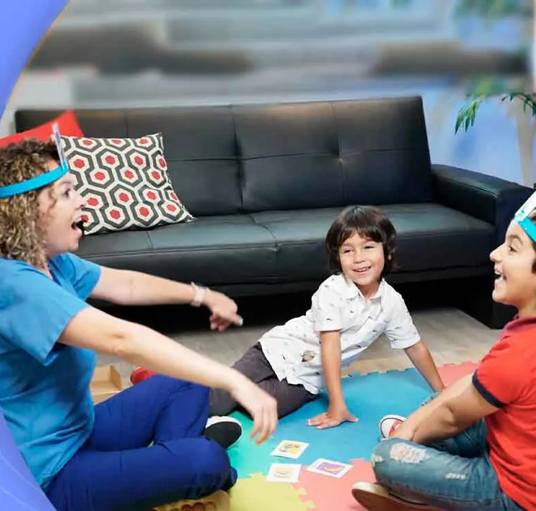 La Dra. Zumbado jugando con niños durante una sesión de terapia